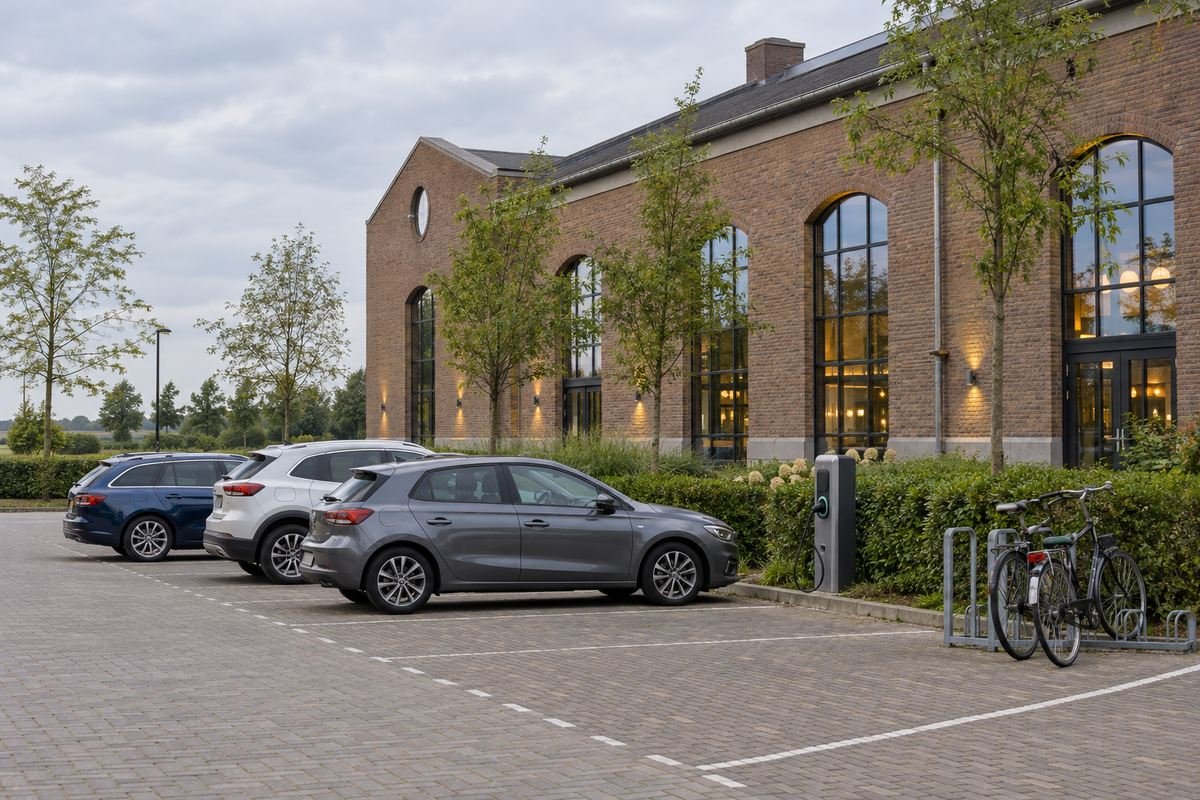 Parkeerplaats naast een locatie met auto's, een laadpaal en een fietsenrek